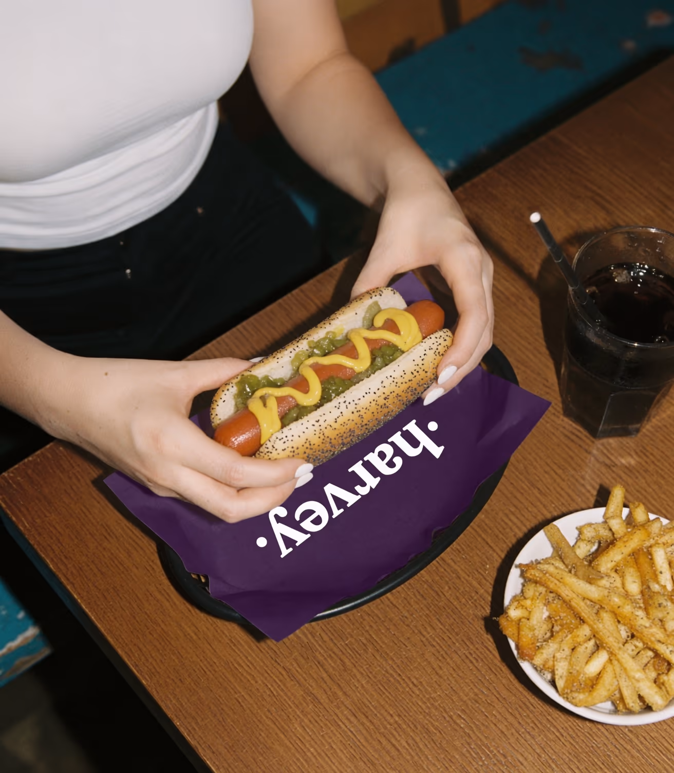 Restoran masasında üstten çekilmiş sosisli sandviç, patates kızartması ve atıştırmalıklar